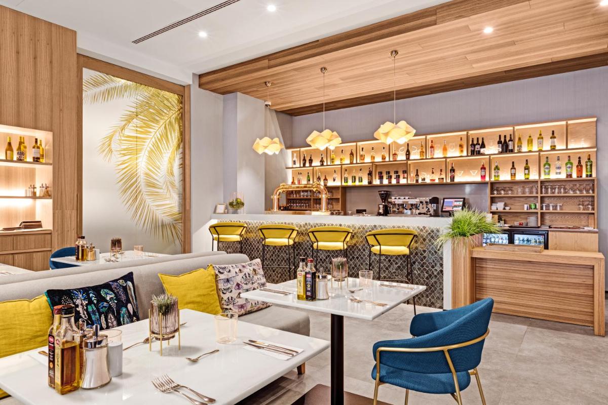 Un restaurante con dos mesas y una barra. en Protur Naisa Palma Hotel, en Palma de Mallorca