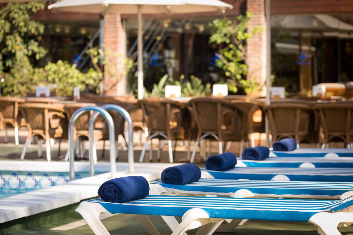 Una fila de masajistas azules en una piscina. en htop Palm Beach & SPA #htopEnjoy, en Lloret de Mar