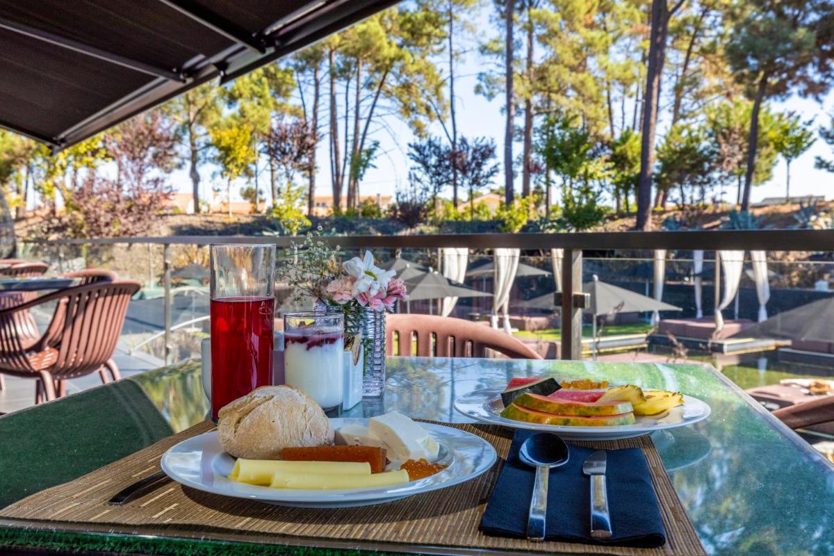 uma mesa com dois pratos de comida sobre ela em Evidencia Belverde Hotel em Amora mais 47 fotografias