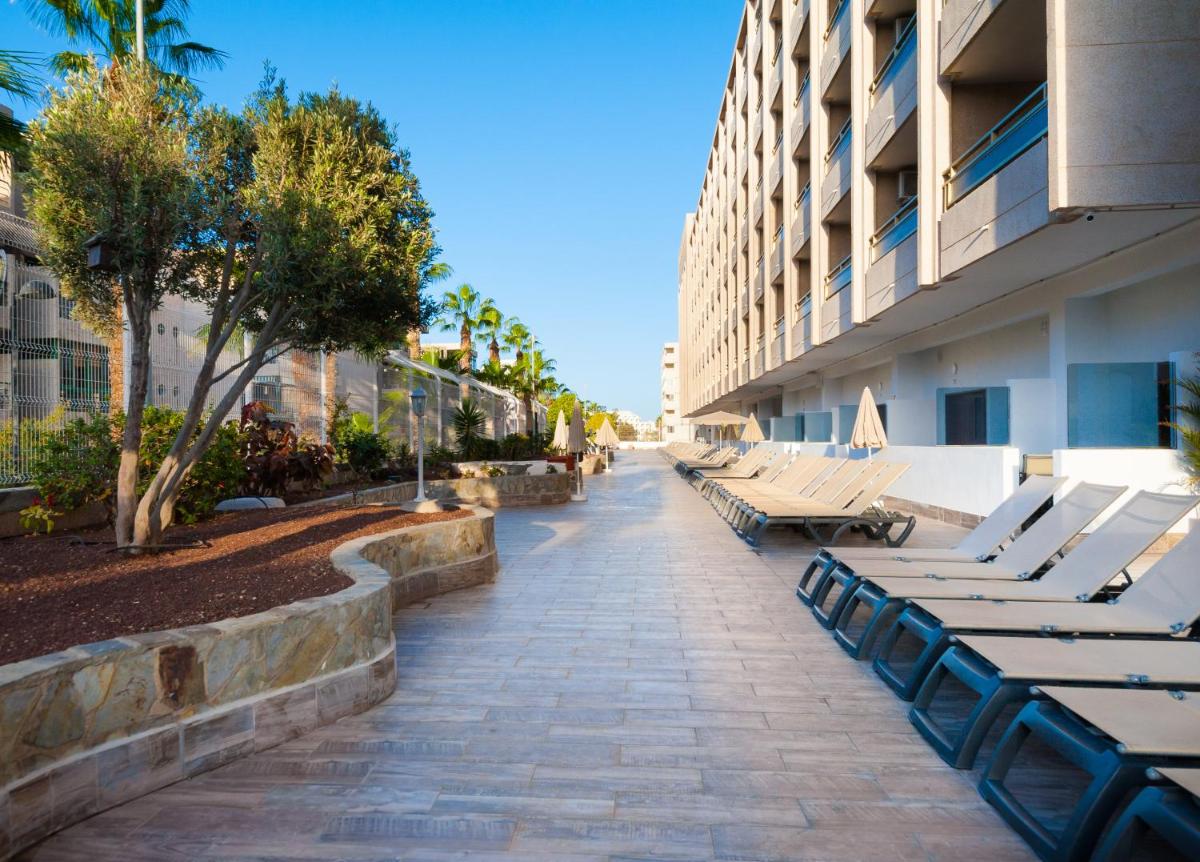 una fila de tumbonas junto a un edificio en Kn Aparthotel Columbus, en Playa de las Américas