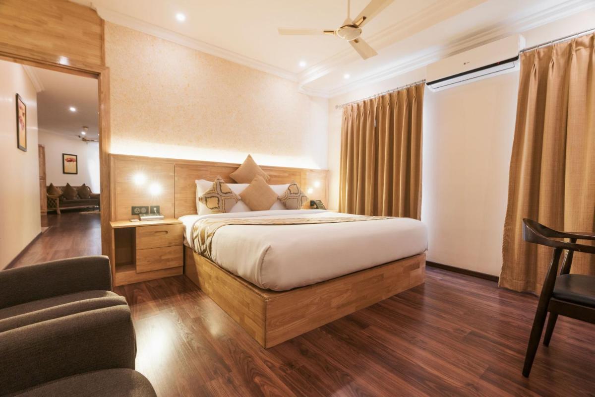 a bedroom with a bed and a couch and a chair at The Panoramic Getaway in Munnar