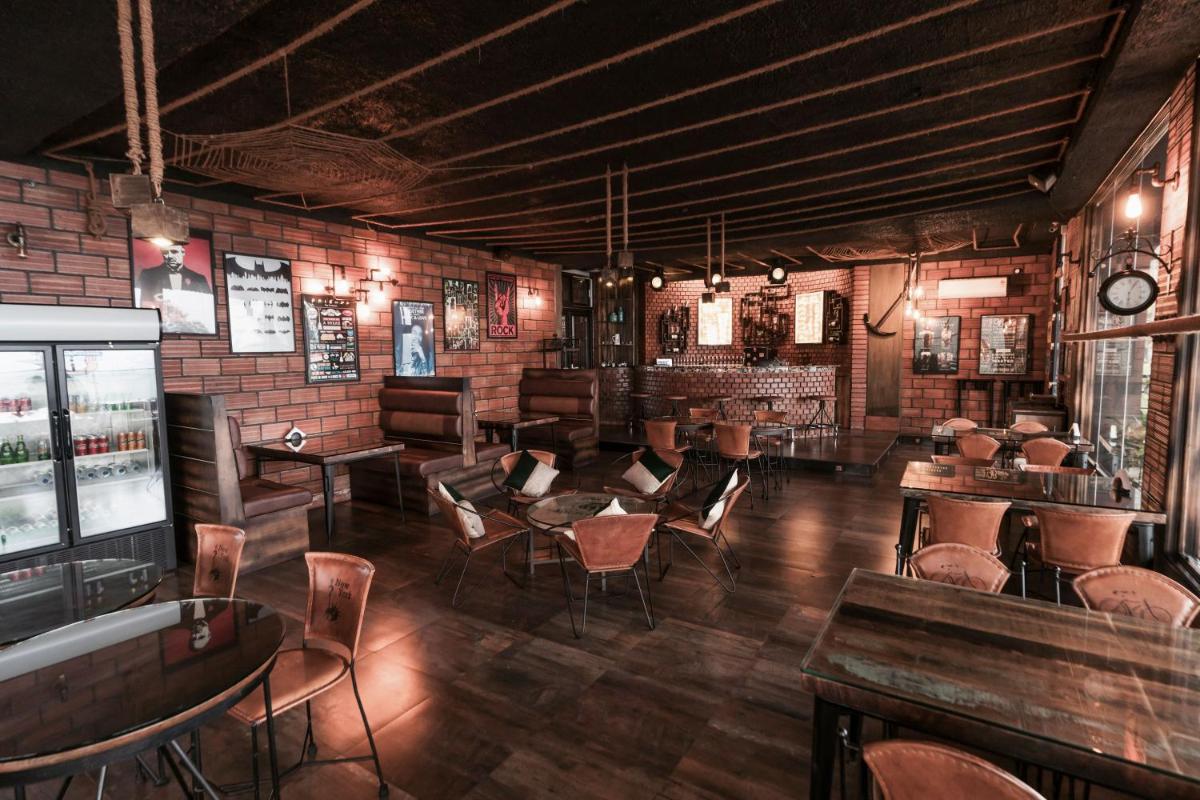 a bar with chairs and tables and a brick wall at The Panoramic Getaway in Munnar