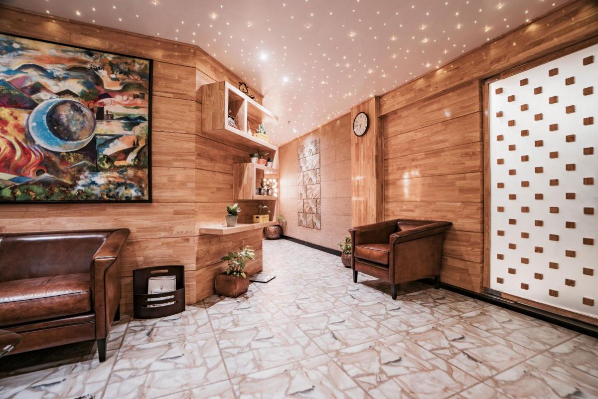 a lobby with two chairs and a painting on the wall at The Panoramic Getaway in Munnar