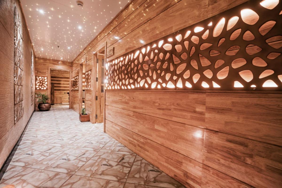 a hallway with wood paneling and a wall with lights at The Panoramic Getaway in Munnar