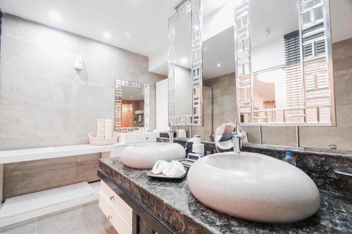 a bathroom with two sinks and a large mirror at The Panoramic Getaway in Munnar