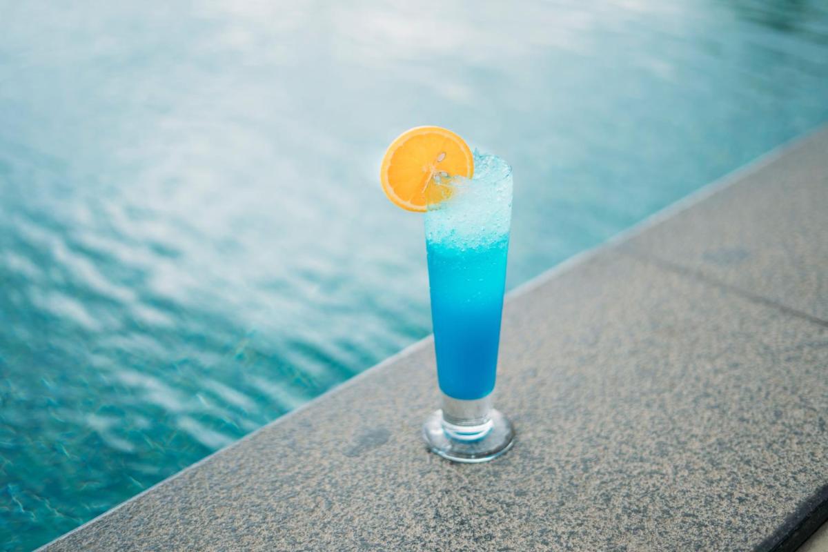 a blue drink sitting on a table next to the water at The Panoramic Getaway in Munnar