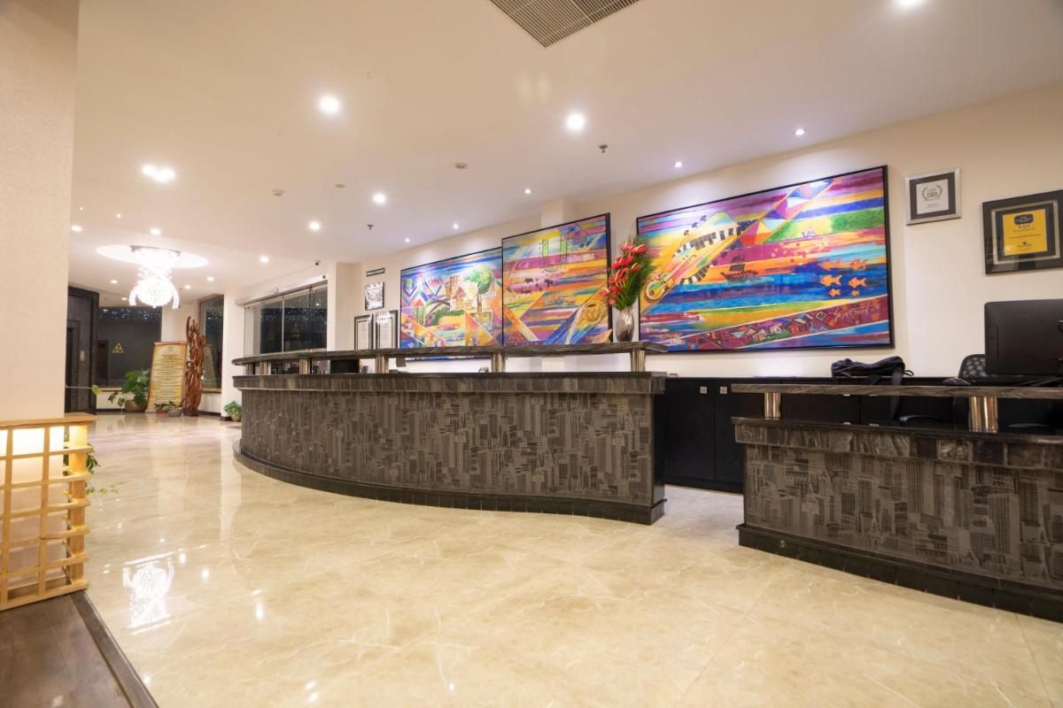 a lobby with a bar with colorful paintings on the wall at The Panoramic Getaway in Munnar