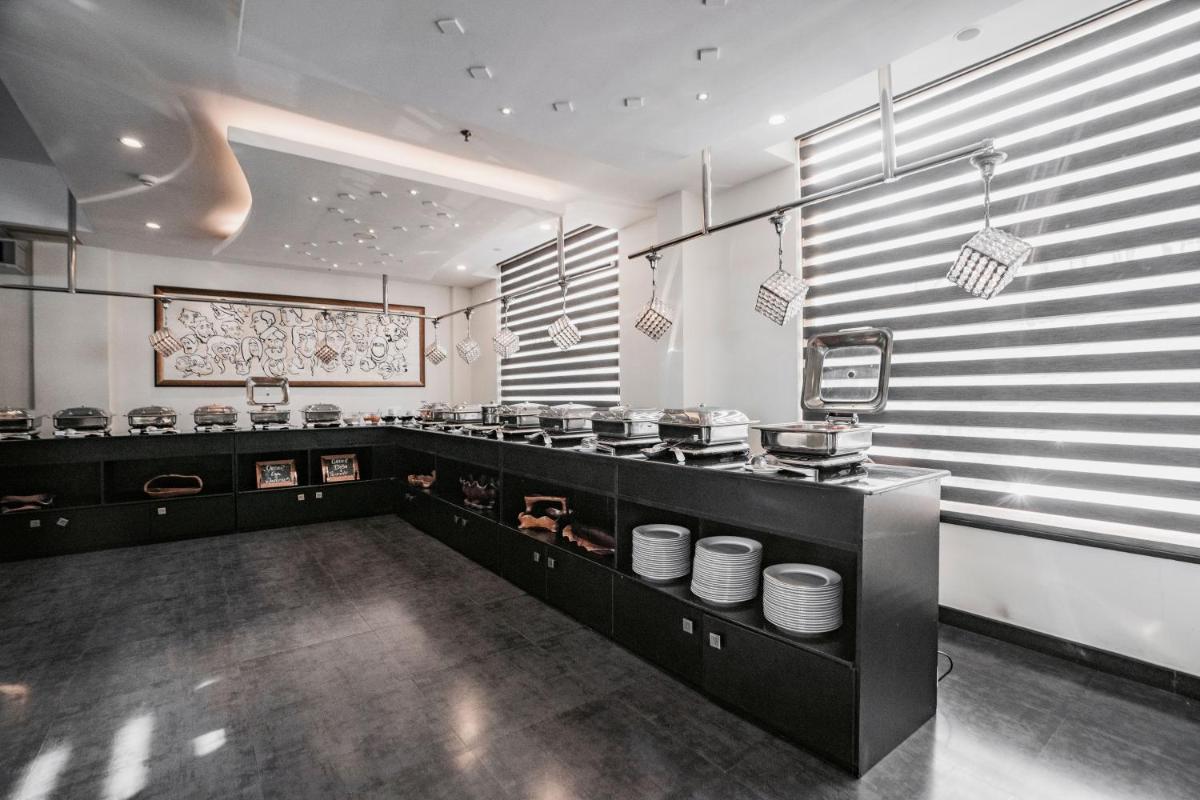 a kitchen with black counters and white dishes at The Panoramic Getaway in Munnar