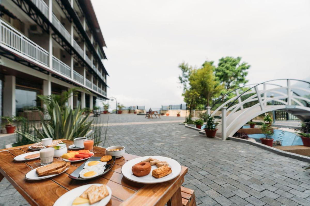 a table with plates of food on top of a building at The Panoramic Getaway in Munnar