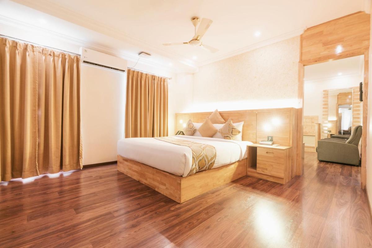 a bedroom with a bed and a chair in a room at The Panoramic Getaway in Munnar