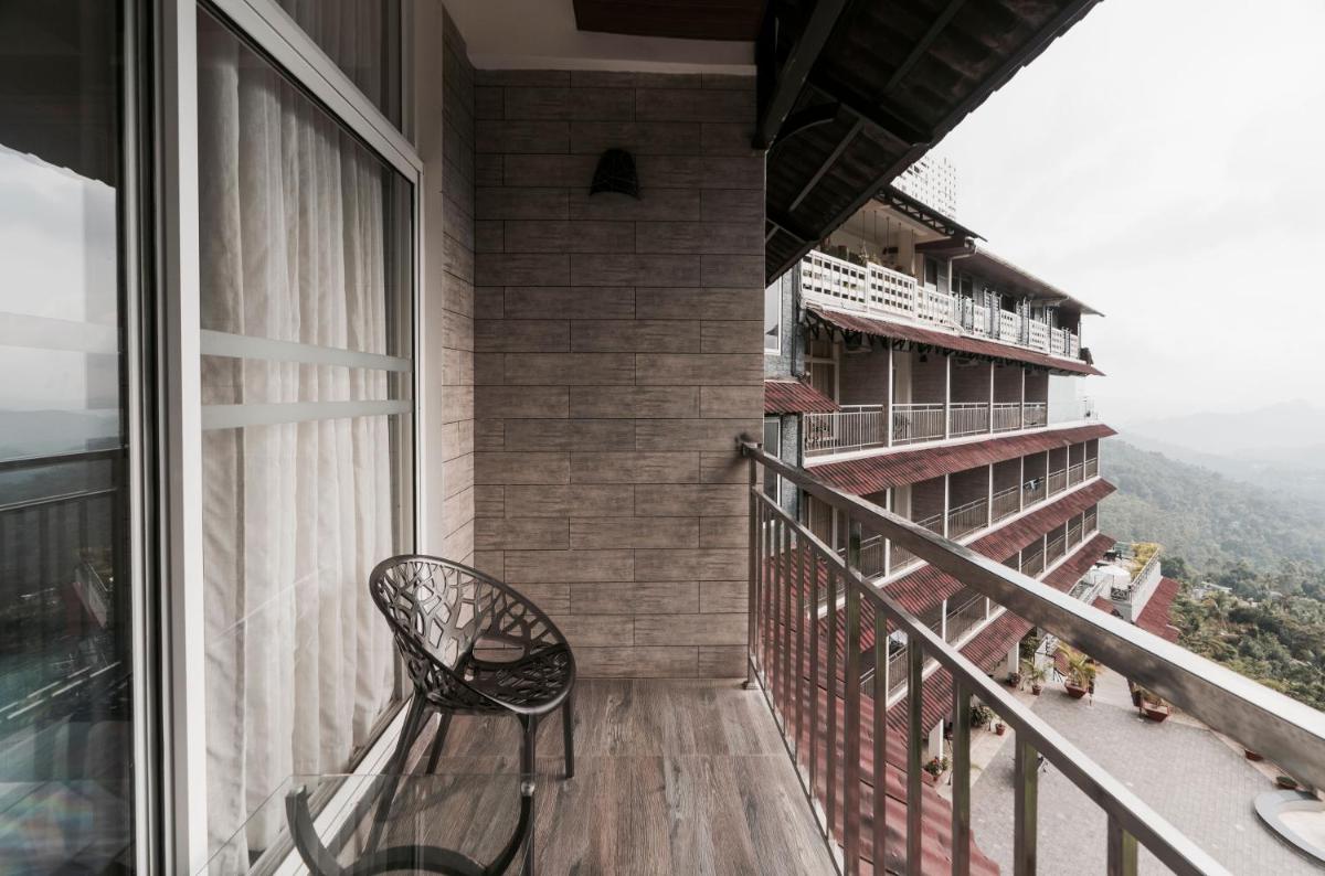 a balcony with a bench and a view of the mountains at The Panoramic Getaway in Munnar