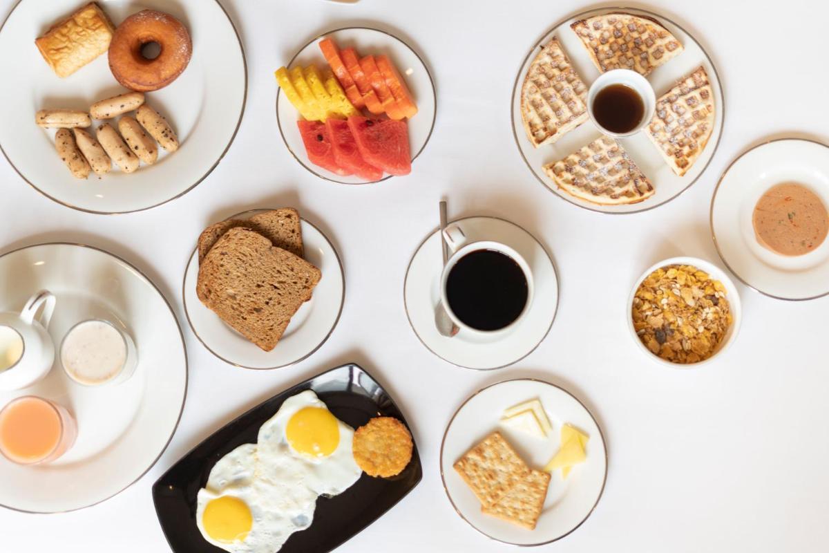 a table with plates of breakfast foods and coffee at The Panoramic Getaway in Munnar