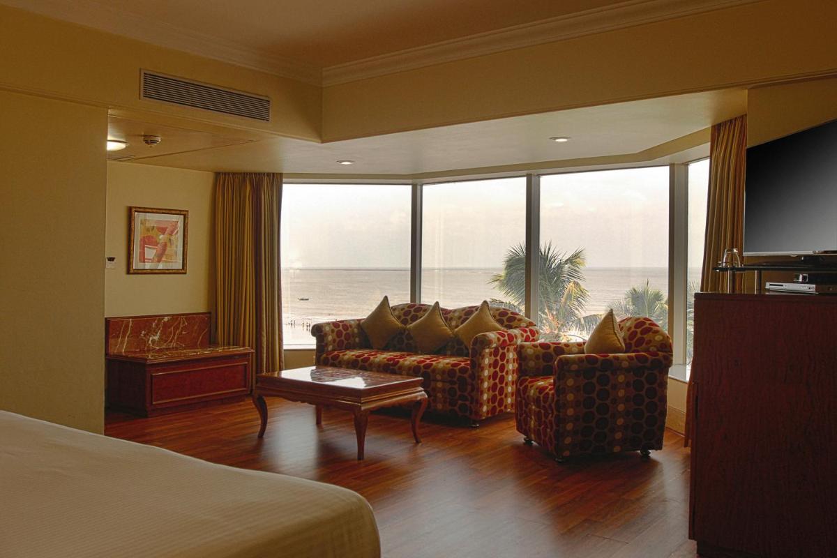 a hotel room with a living room with a view of the ocean at Ramada Plaza By Wyndham Palm Grove in Mumbai