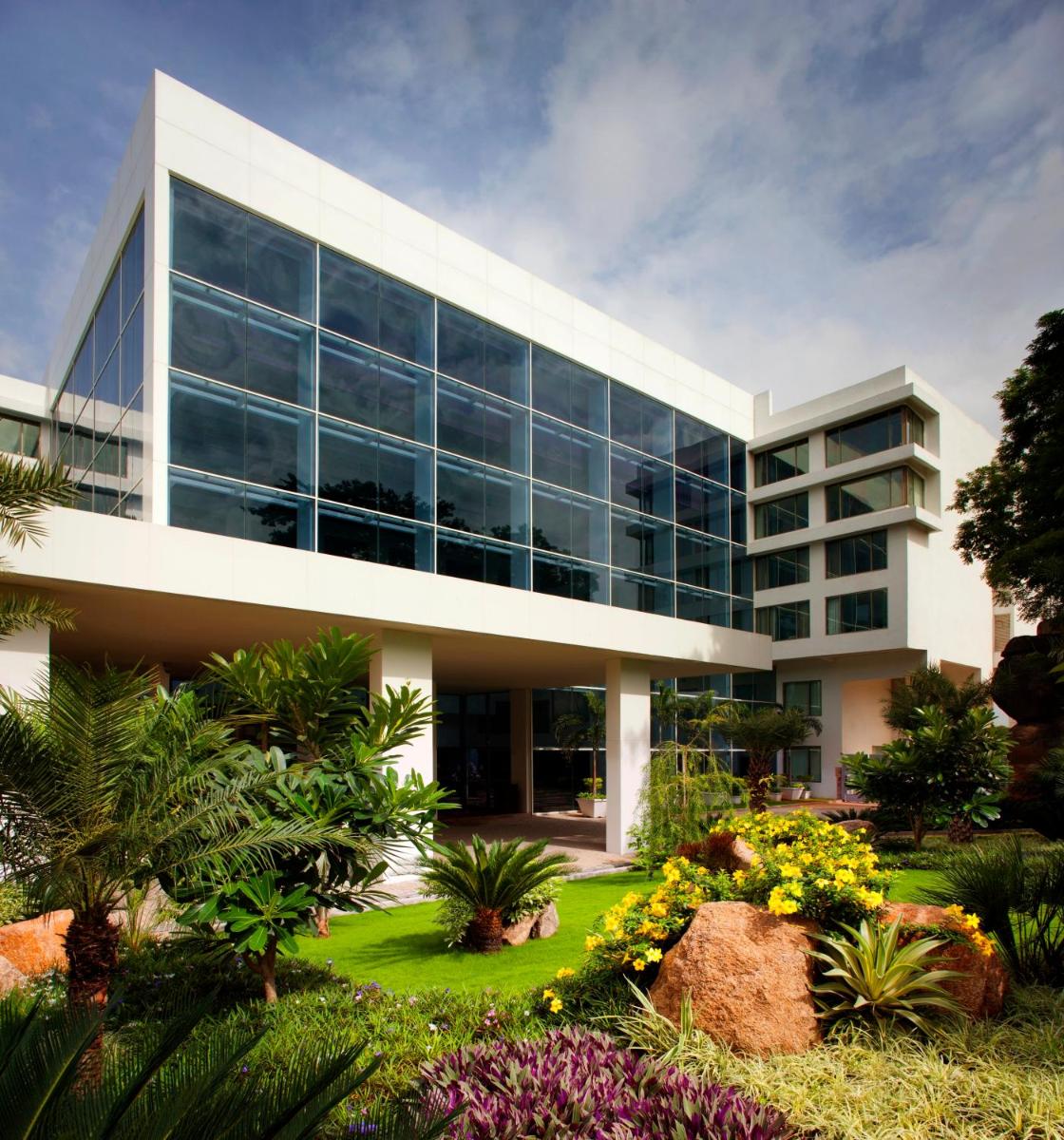an office building with a garden in front of it at Radisson Blu Plaza Hotel Hyderabad Banjara Hills in Hyderabad an office building with a garden in front of it at Radisson Blu Plaza Hotel Hyderabad Banjara Hills in Hyderabad