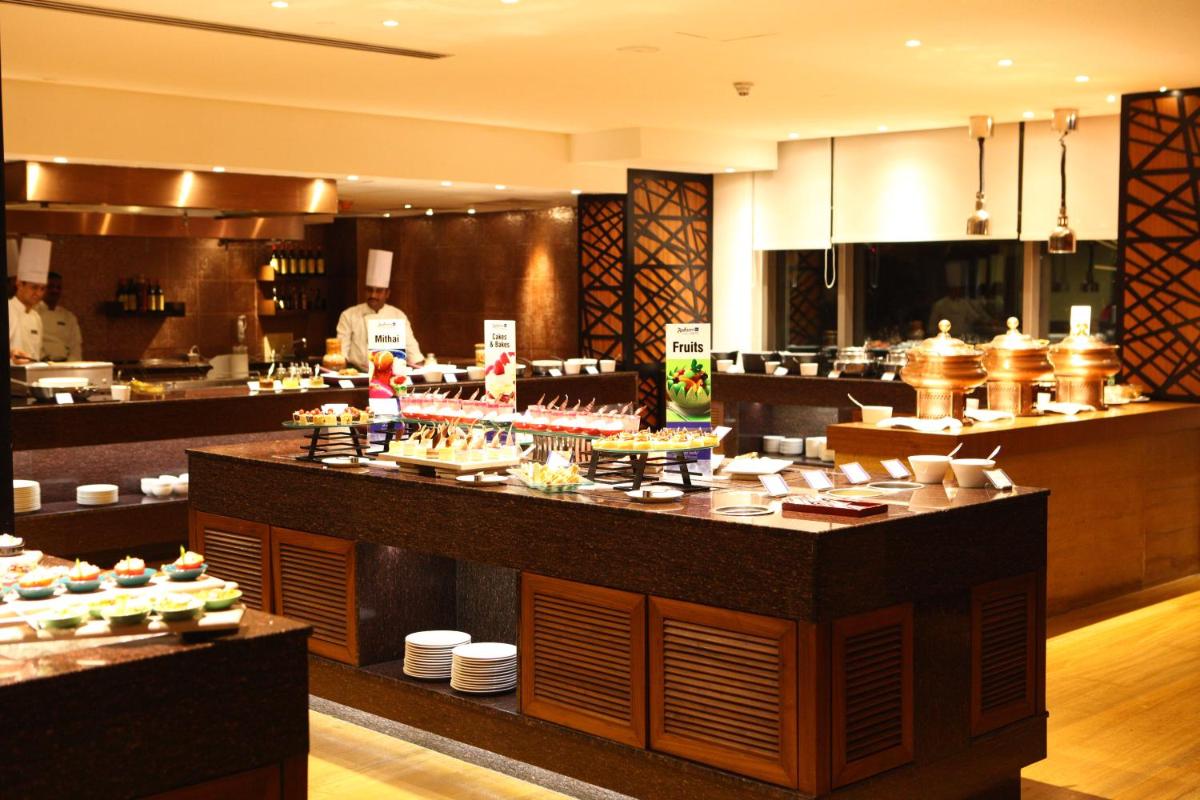 a restaurant kitchen with a counter with food on it at Radisson Blu Plaza Hotel Hyderabad Banjara Hills in Hyderabad a restaurant kitchen with a counter with food on it at Radisson Blu Plaza Hotel Hyderabad Banjara Hills in Hyderabad