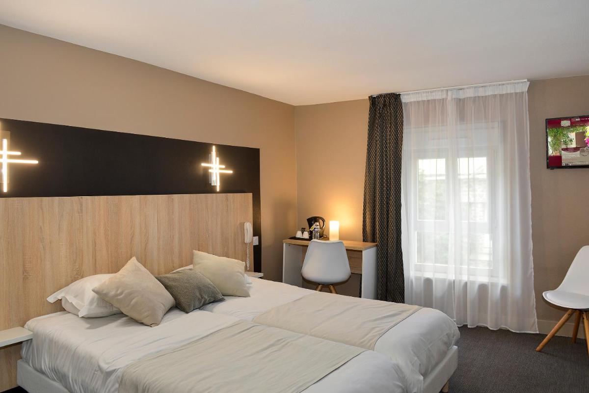Un ou plusieurs lits dans un hébergement de l'établissement Logis Hotel Spa Restaurant Au Site Normand