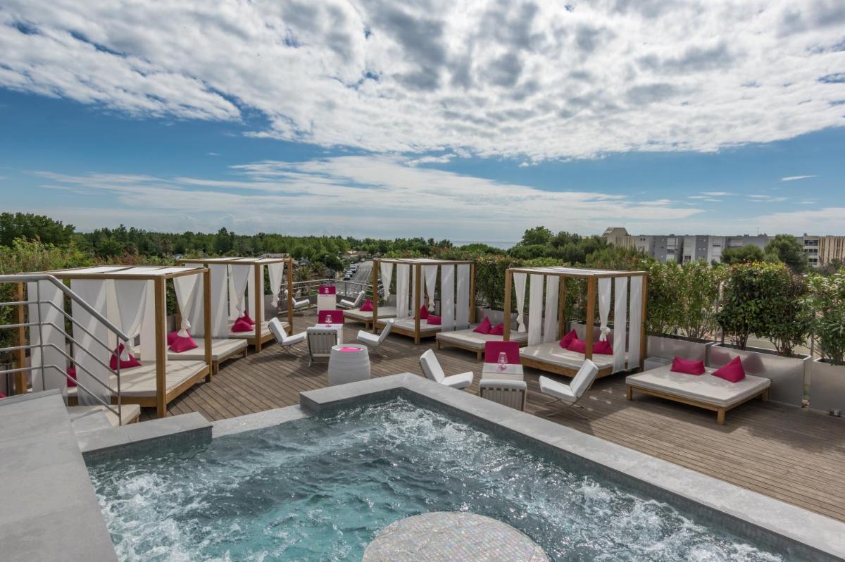 une terrasse avec des chaises et une piscine sur le toit dans l'établissement Oz'Inn Hôtel & Spa, au Cap d'Agde