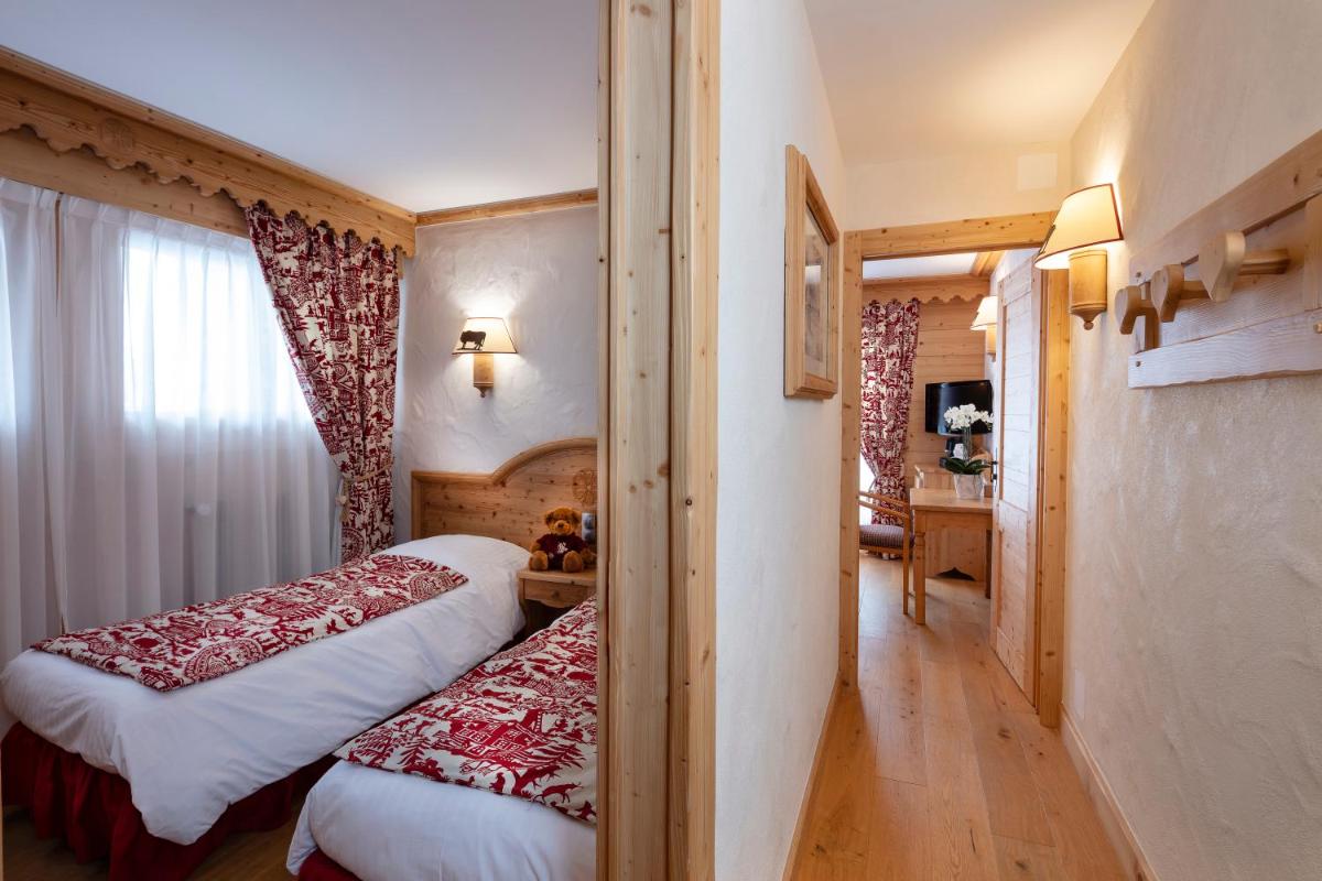 Un ou plusieurs lits dans un hébergement de l'établissement Chalet-Hôtel Neige et Roc, The Originals Relais