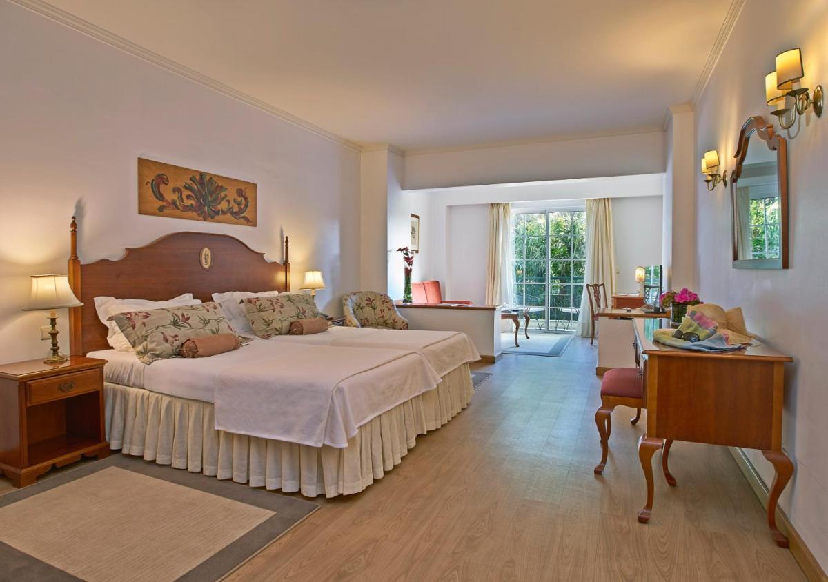 um quarto com uma cama grande num quarto com uma mesa em Quintinha Sao Joao Hotel & Spa no Funchal mais 64 fotografias