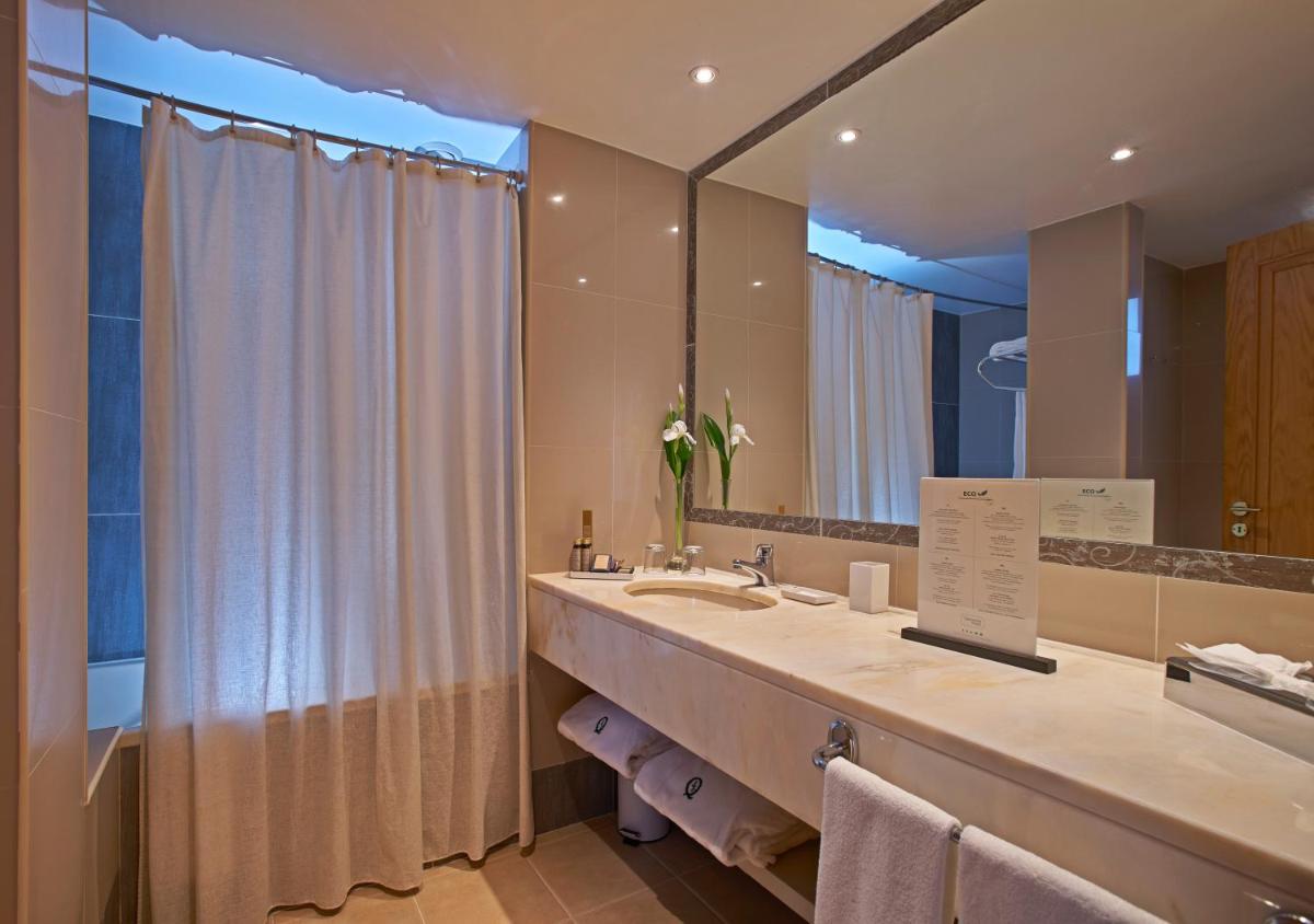 um banheiro com uma pia e um espelho grande em Quintinha Sao Joao Hotel & Spa no Funchal