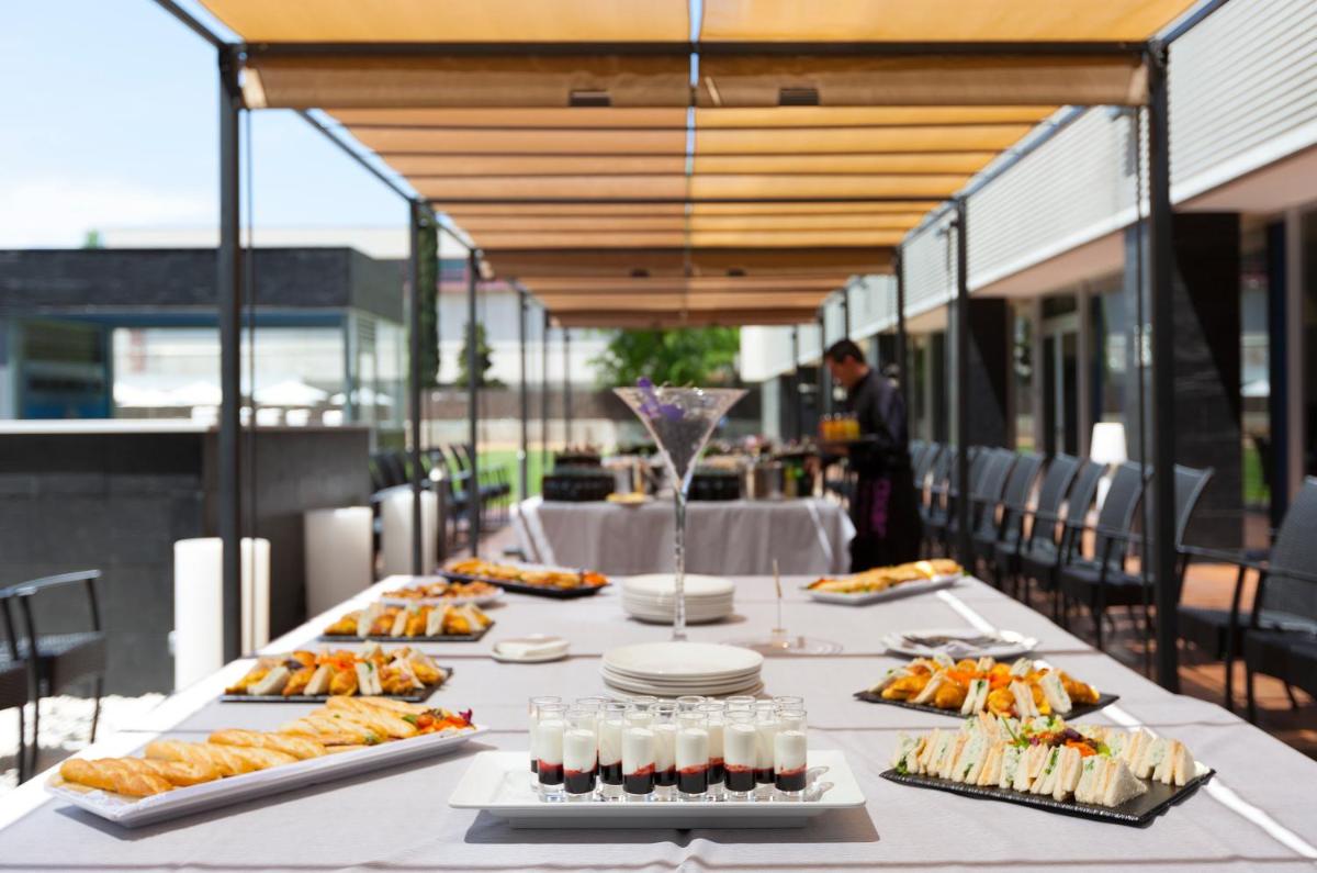 Una mesa larga con platos de comida encima. en Axor Barajas, en Madrid