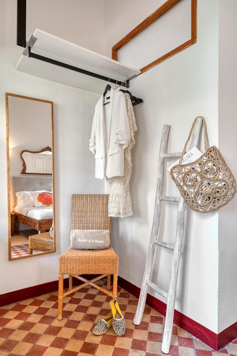 Habitación con escalera, silla y espejo. en Hotel Can Roses, en Sóller