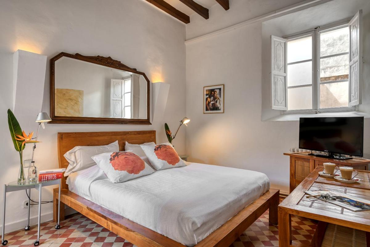 Un dormitorio con una cama con un espejo y una mesa. en Hotel Can Roses, en Sóller
