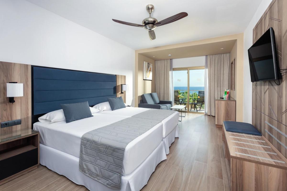 Una habitación de hotel con una cama grande y un televisor. en Hotel Riu Palace Oasis, en Maspalomas