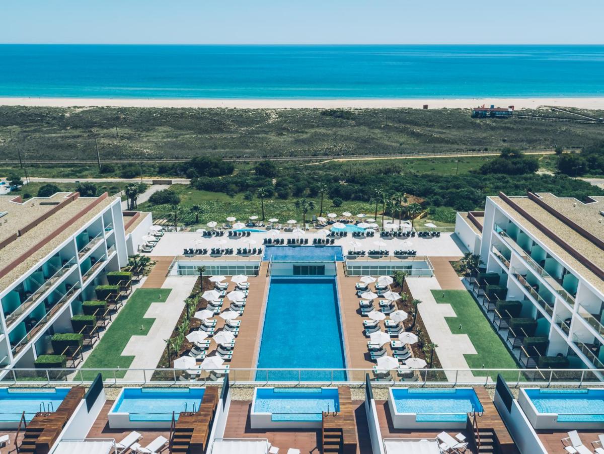 uma vista aérea de um resort com piscina e o oceano em Iberostar Selection Lagos Algarve em Lagos