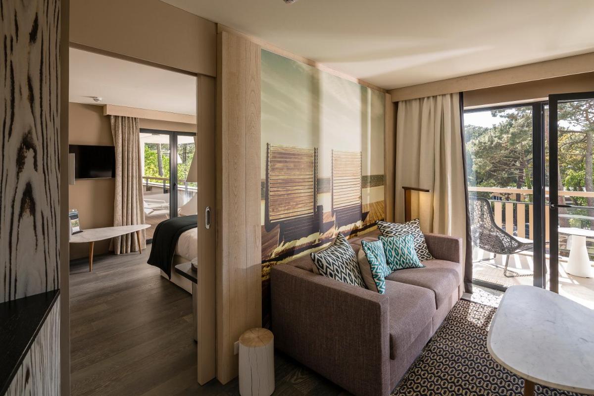 d'un salon avec un canapé et un balcon. dans l'établissement Thalazur Arcachon, à Arcachon