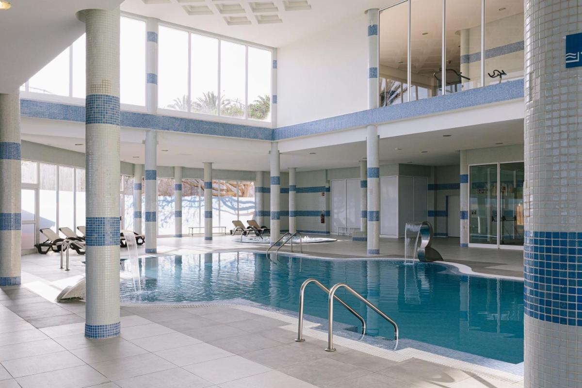 una gran piscina en un edificio con una persona sentada en él en Alua Village Fuerteventura - All Inclusive, en Playa de Jandía 59 fotos más