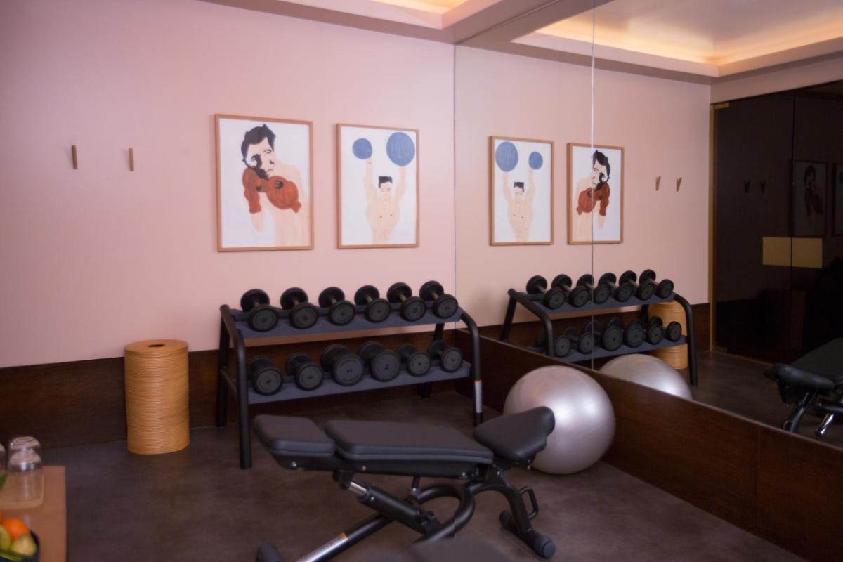 uma sala de espera com um monte de cadeiras e fotos na parede em The Vintage Hotel & Spa Lisbon em Lisboa