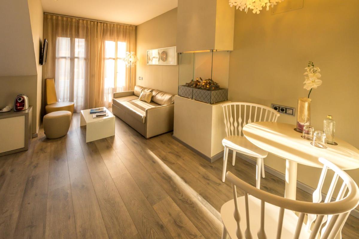 una sala de estar con una mesa y un sofá en Hotel & Spa Princesa Munia, en Oviedo