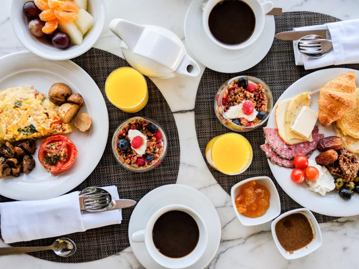a table with plates of breakfast foods and cups of coffee at Four Seasons Hotel Bengaluru at Embassy ONE in Bengaluru a table with plates of breakfast foods and cups of coffee at Four Seasons Hotel Bengaluru at Embassy ONE in Bengaluru