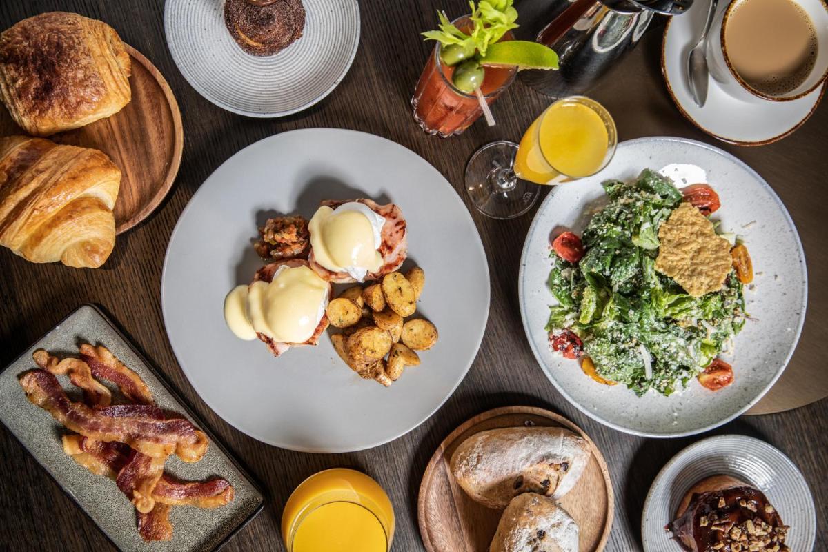 a table with plates of breakfast foods and drinks at Four Seasons Hotel Bengaluru at Embassy ONE in Bengaluru a table with plates of breakfast foods and drinks at Four Seasons Hotel Bengaluru at Embassy ONE in Bengaluru