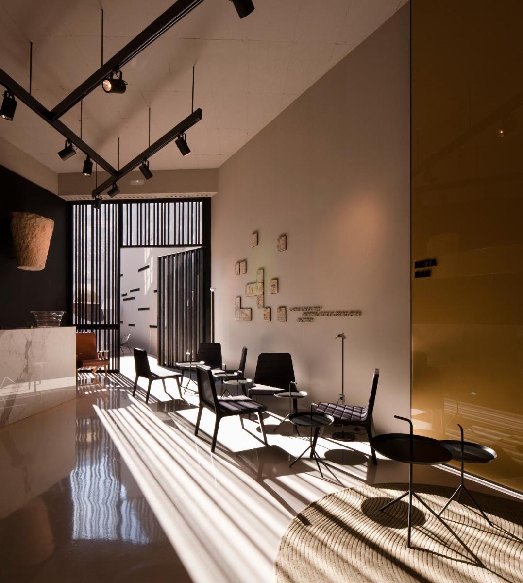 una habitación con sillas y mesas y una piscina en Caro Hotel, en Valencia