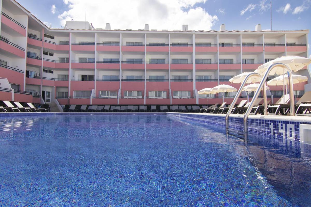 uma piscina em frente a um prédio em Luna Hotel da Oura em Albufeira uma piscina em frente a um prédio em Luna Hotel da Oura em Albufeira