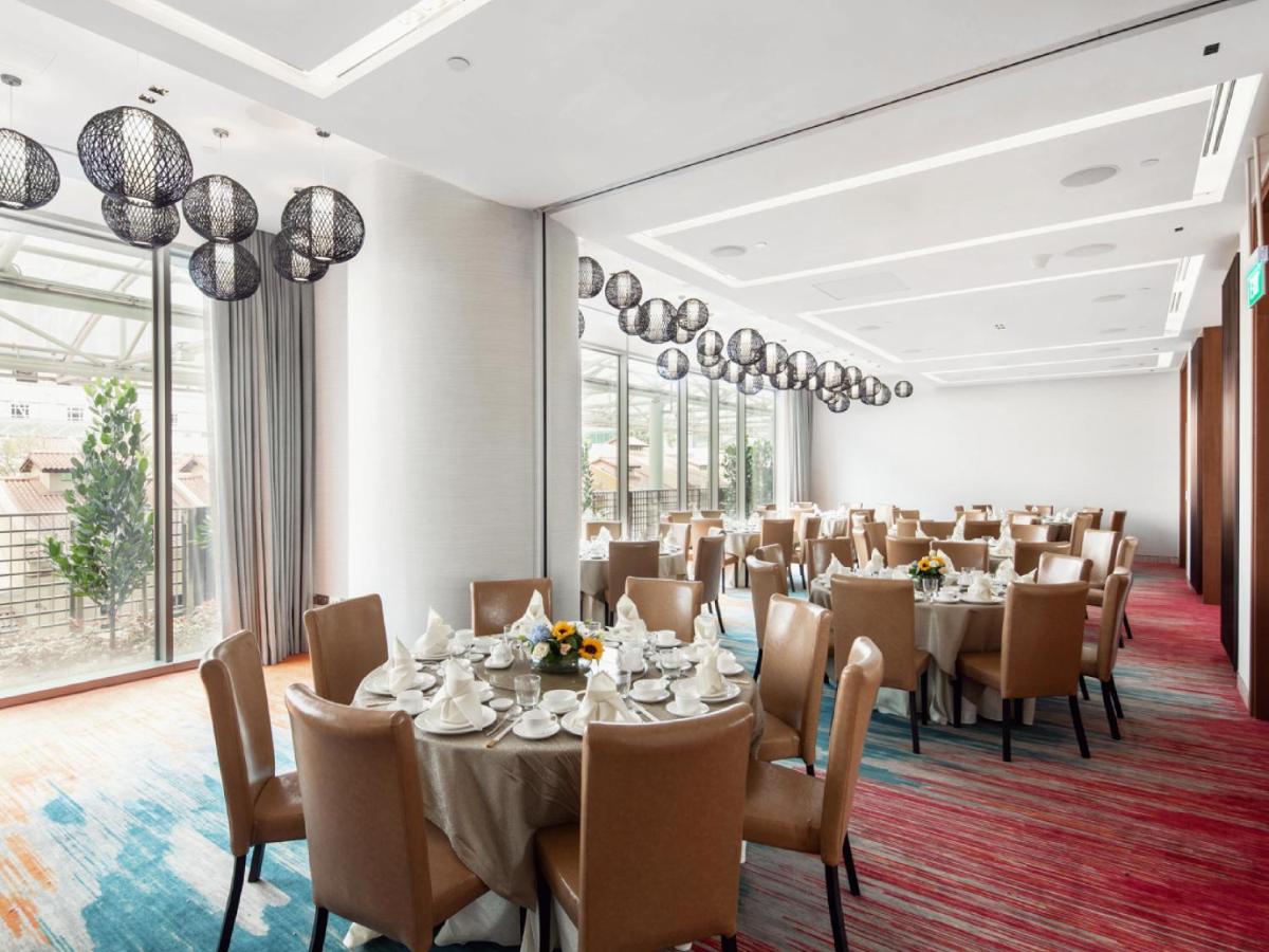 a banquet room with tables and chairs and large windows at Capri by Fraser China Square, Singapore in Singapore