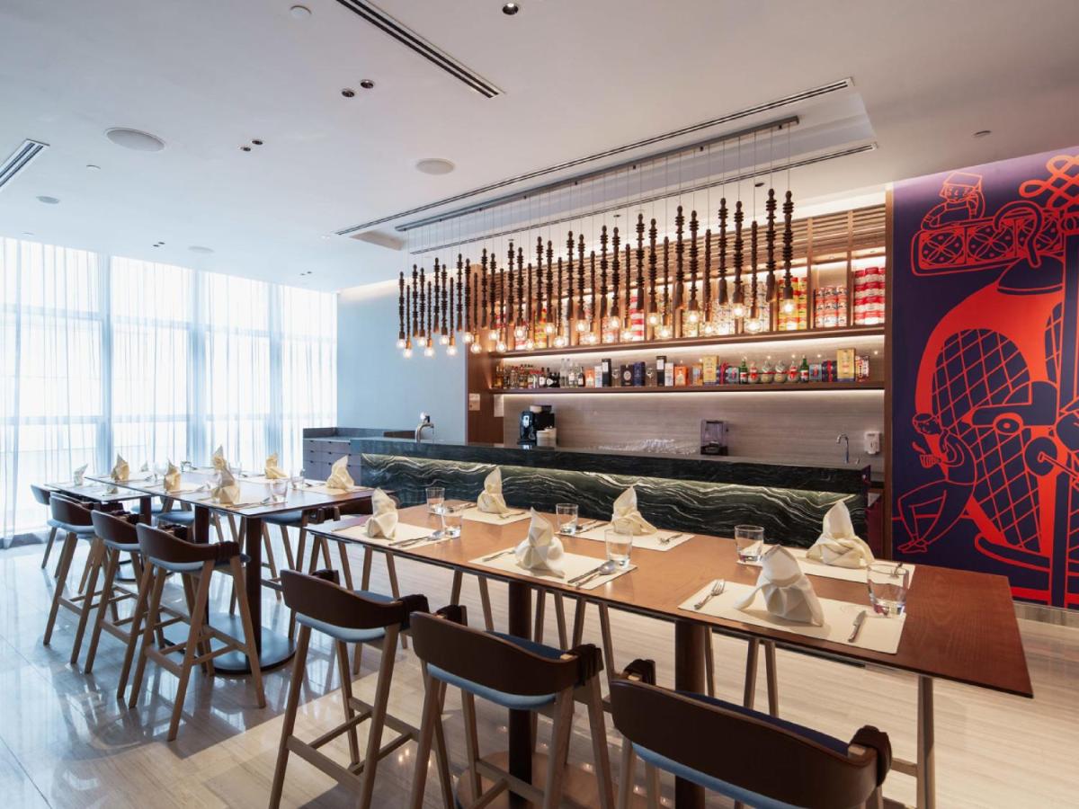 a restaurant with tables and chairs and a bar at Capri by Fraser China Square, Singapore in Singapore