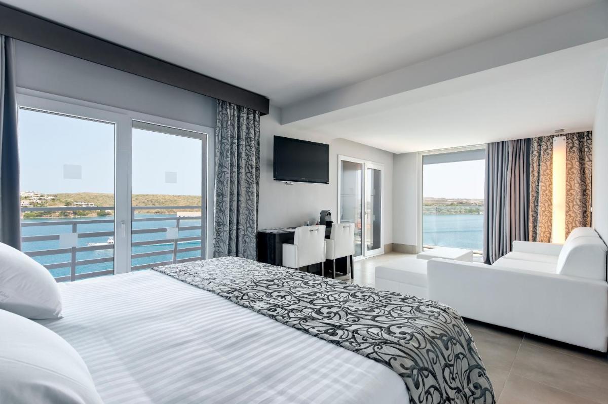 Un dormitorio con una cama grande y una ventana grande. en Barceló Hamilton Menorca - Adults Only, en Es Castell