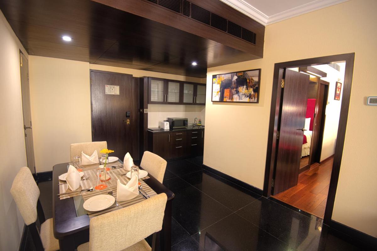 a room with a dining table and a kitchen at Sterlings Mac Hotel in Bengaluru