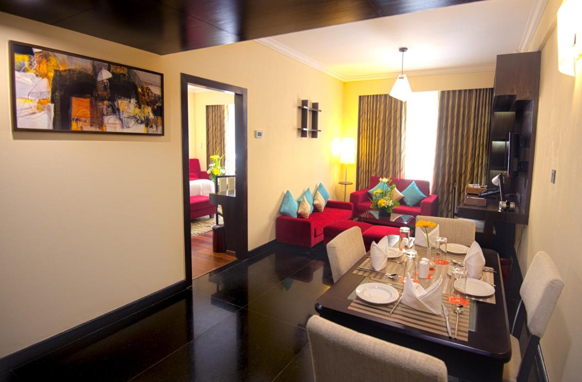 a room with a dining table and a living room at Sterlings Mac Hotel in Bengaluru