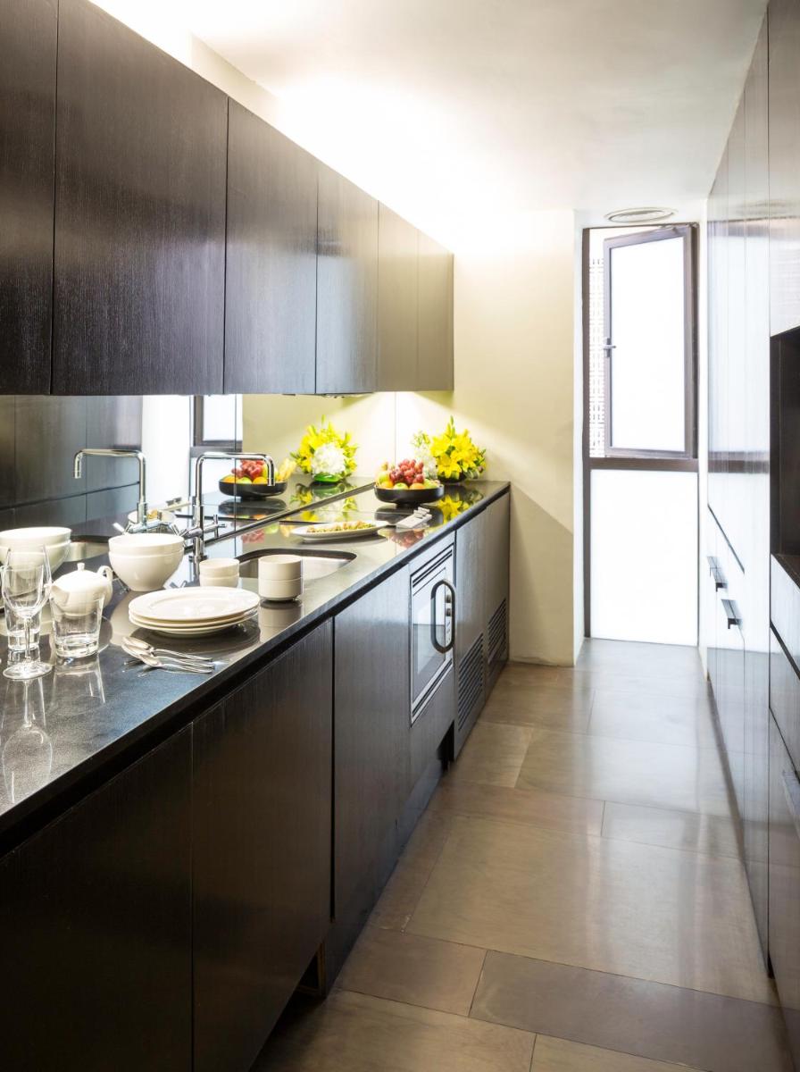 a kitchen with black cabinets and a counter top at The Lodhi – A member of The Leading Hotels Of The World in New Delhi