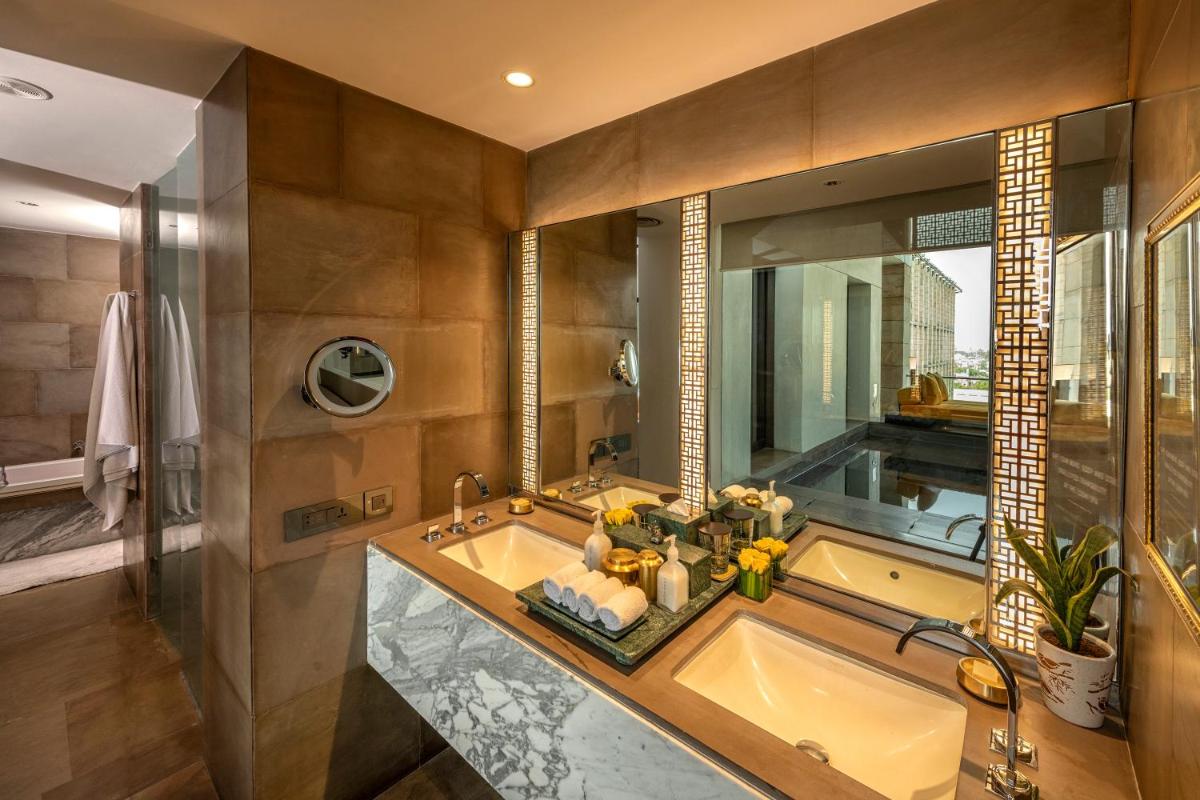 a bathroom with a tub and a large mirror at The Lodhi – A member of The Leading Hotels Of The World in New Delhi