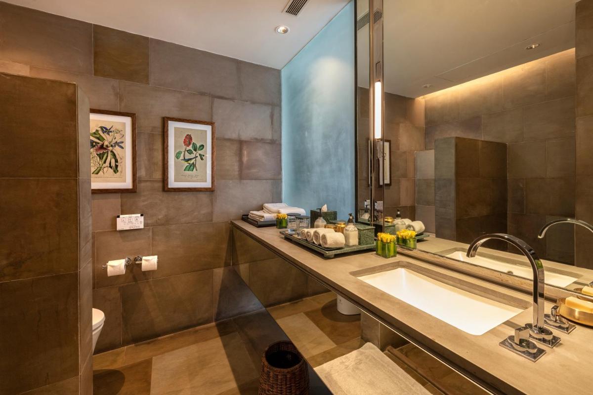 a bathroom with a sink and a large mirror at The Lodhi – A member of The Leading Hotels Of The World in New Delhi