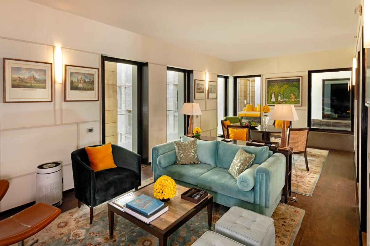 a living room with a blue couch and a table at The Lodhi – A member of The Leading Hotels Of The World in New Delhi