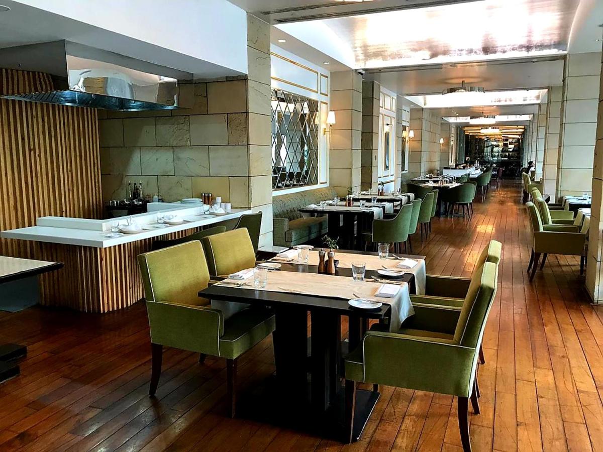 a dining room with tables and chairs in a restaurant at The Lodhi – A member of The Leading Hotels Of The World in New Delhi