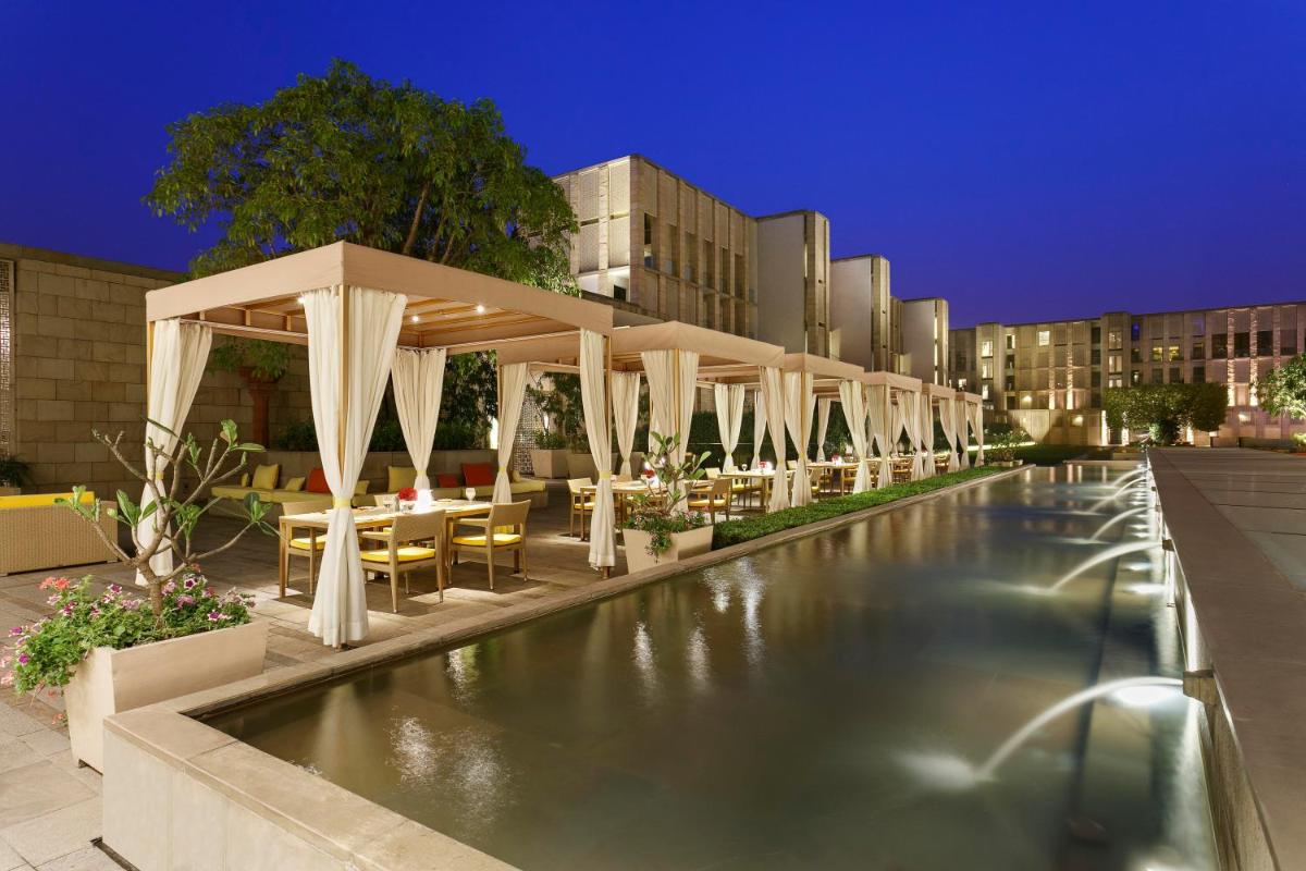 a pool with tables and chairs and a pavilion at The Lodhi – A member of The Leading Hotels Of The World in New Delhi