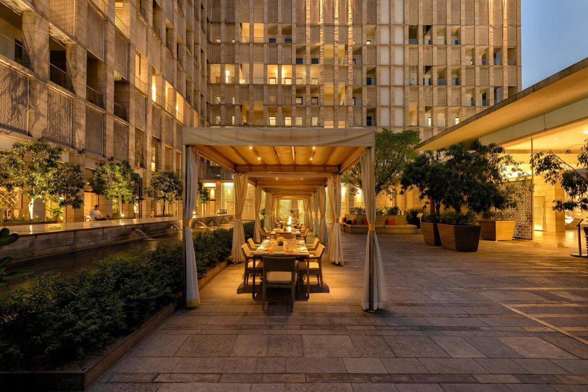 a restaurant with a table in the middle of a building at The Lodhi – A member of The Leading Hotels Of The World in New Delhi
