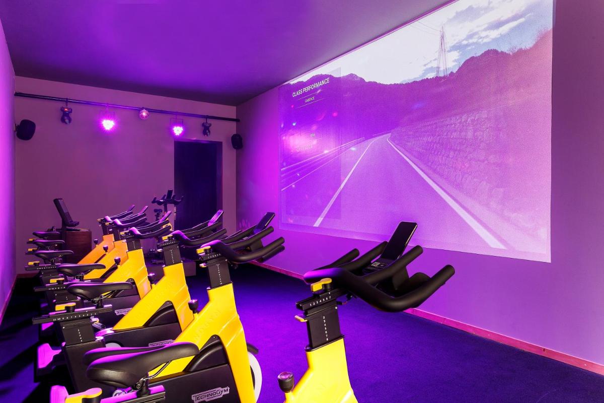 a gym with rows of exercise bikes in a purple room at The Lodhi – A member of The Leading Hotels Of The World in New Delhi